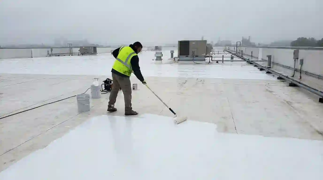 Rolling silicone coating over a roof membrane